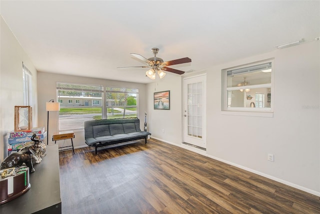 living room featuring ceiling fan and dark hardwood / wood-style floors