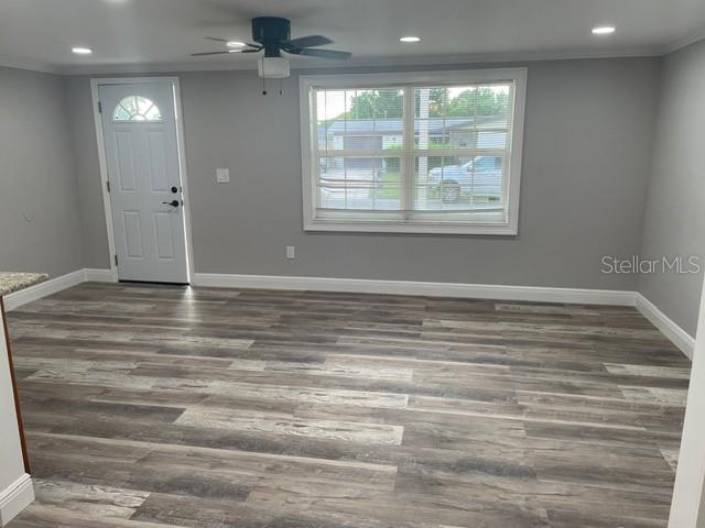 entryway with ornamental molding, ceiling fan, and dark hardwood / wood-style flooring