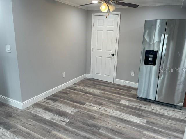 interior space featuring dark hardwood / wood-style flooring, ornamental molding, and ceiling fan