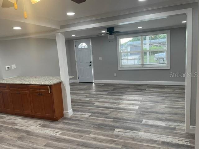 foyer featuring light hardwood / wood-style floors, crown molding, and ceiling fan