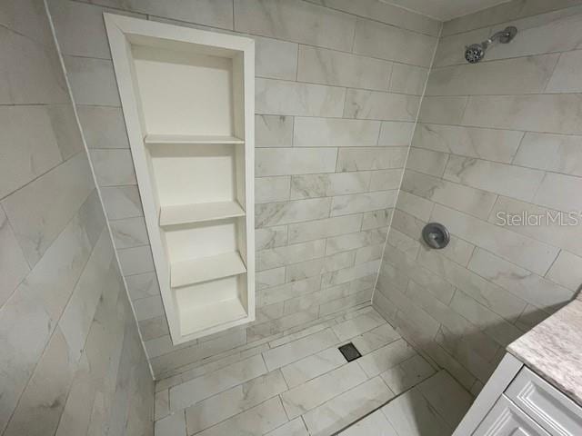 bathroom with vanity and a tile shower