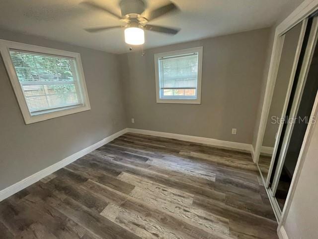 unfurnished bedroom featuring dark hardwood / wood-style flooring, a closet, and ceiling fan