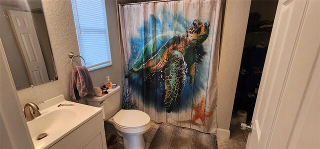 bathroom featuring tile patterned floors, curtained shower, vanity, and toilet