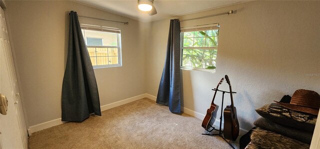 interior space with lofted ceiling, ceiling fan, and light colored carpet