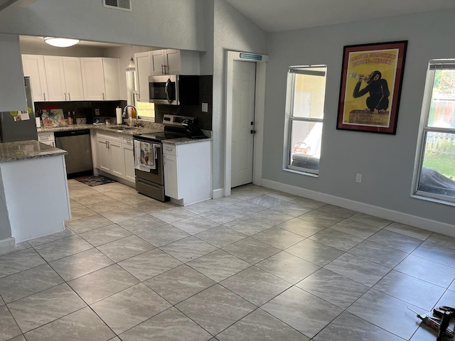 kitchen featuring white cabinets, appliances with stainless steel finishes, stone countertops, and sink