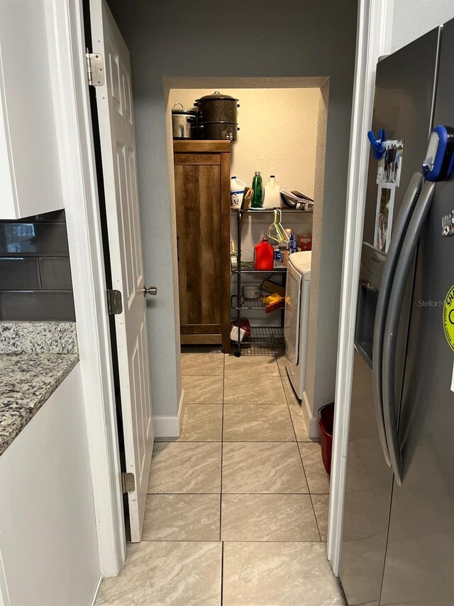 laundry room featuring washer / dryer and light tile patterned floors