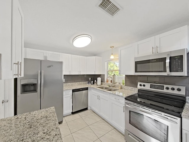 kitchen featuring visible vents, decorative backsplash, appliances with stainless steel finishes, white cabinets, and a sink