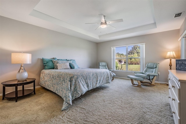 bedroom featuring ceiling fan, carpet, and a tray ceiling