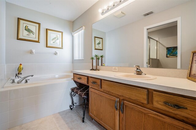 bathroom with independent shower and bath, vanity, and tile patterned floors