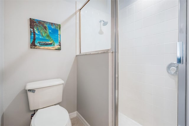 bathroom featuring toilet and a shower with shower door