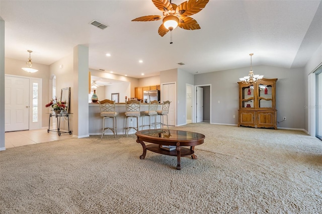 carpeted living room featuring plenty of natural light, lofted ceiling, and ceiling fan with notable chandelier