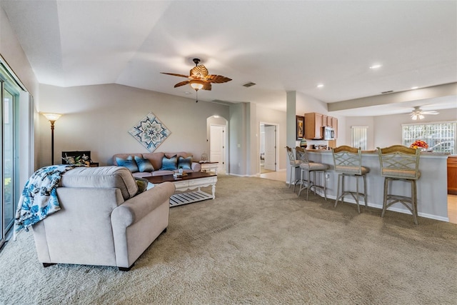 living room with lofted ceiling, light carpet, and ceiling fan