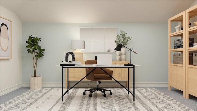 carpeted office featuring lofted ceiling