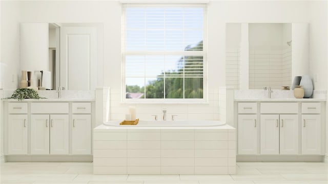 bathroom featuring tiled bath and vanity