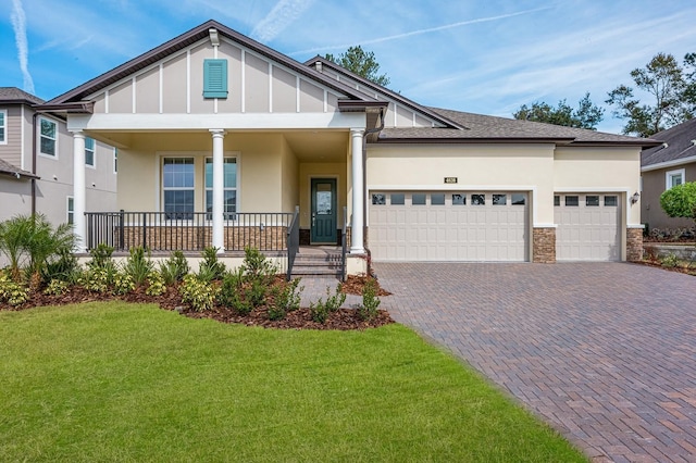 view of front facade with a garage, a front lawn, and covered porch