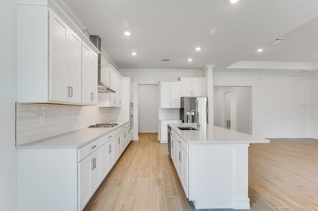 kitchen featuring sink, white cabinetry, light hardwood / wood-style flooring, stainless steel appliances, and a large island