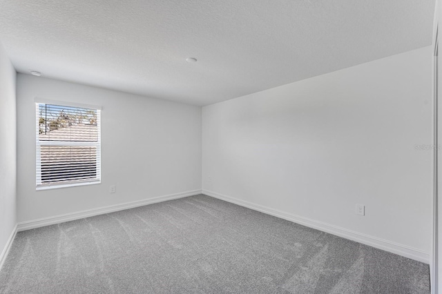 carpeted spare room featuring a textured ceiling