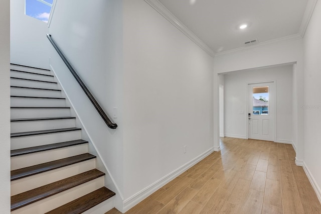 stairs with wood-type flooring and ornamental molding