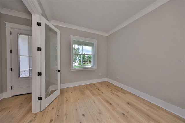 empty room with light hardwood / wood-style floors and crown molding