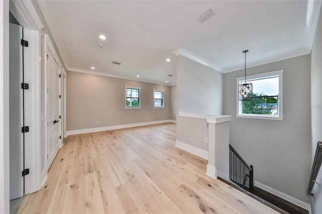 entryway with an inviting chandelier, light wood-type flooring, crown molding, and a wealth of natural light