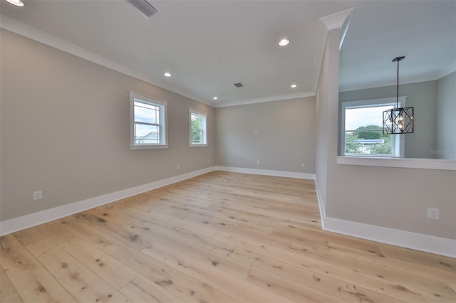 empty room with light hardwood / wood-style flooring, a wealth of natural light, and crown molding