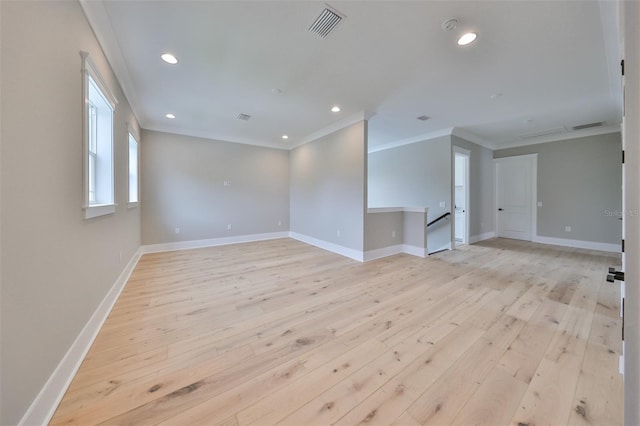 empty room featuring light wood-type flooring and crown molding