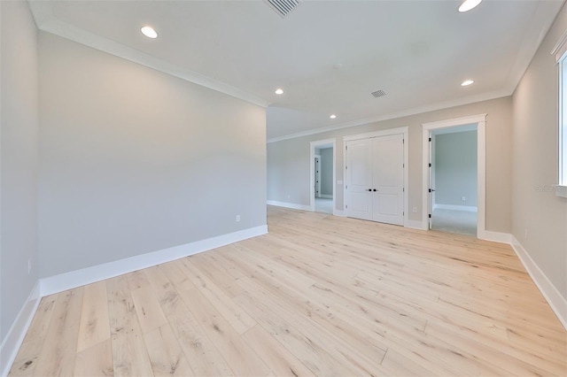 unfurnished room with light wood-type flooring and ornamental molding