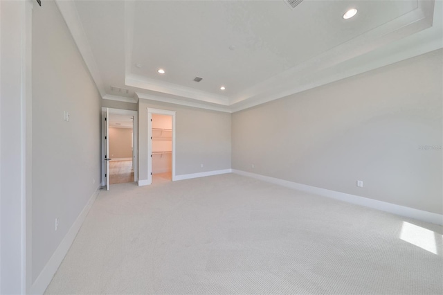 carpeted empty room with a raised ceiling