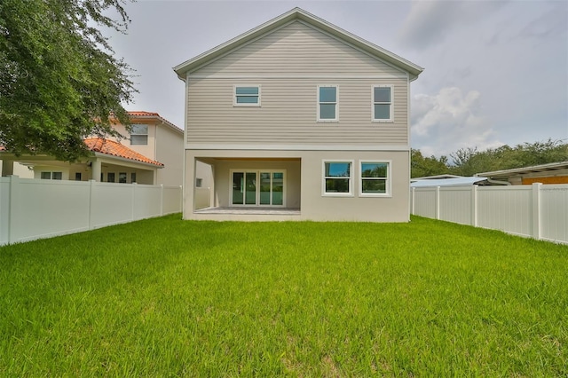 rear view of house with a yard and a patio area