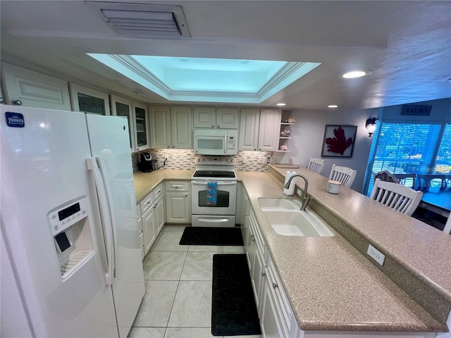 kitchen featuring tasteful backsplash, white appliances, crown molding, a tray ceiling, and sink