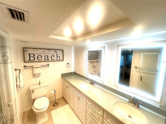 bathroom with tile patterned flooring, a tray ceiling, vanity, and toilet