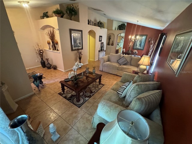 tiled living room featuring vaulted ceiling and a notable chandelier