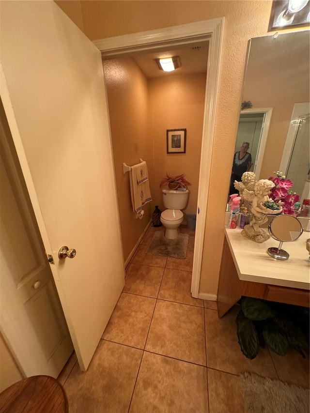 bathroom featuring tile patterned flooring, vanity, and toilet