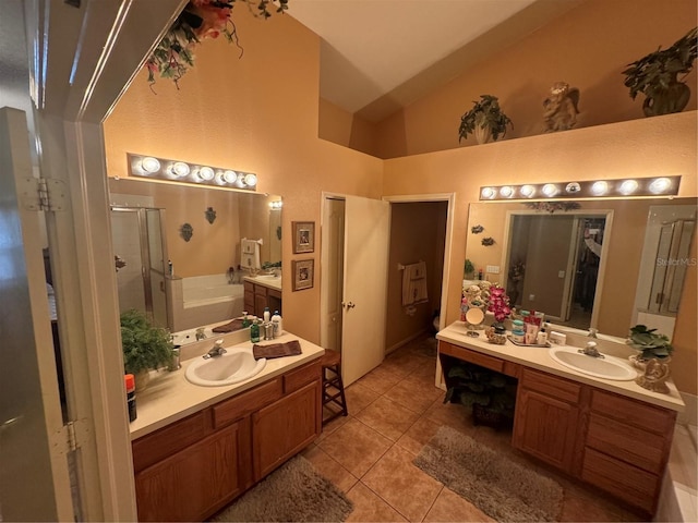 bathroom featuring vaulted ceiling, separate shower and tub, vanity, and tile patterned floors