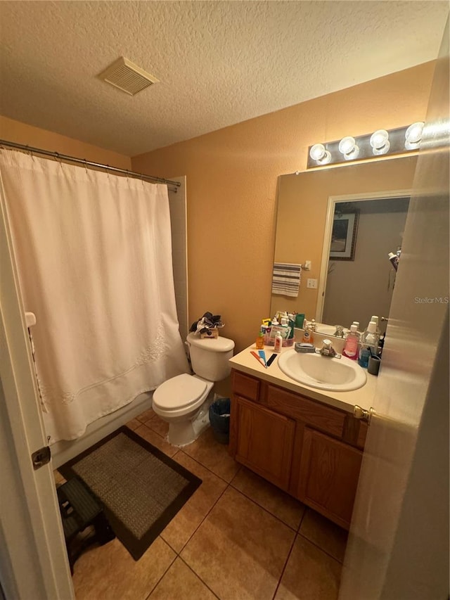 bathroom featuring vanity, a textured ceiling, tile patterned flooring, toilet, and a shower with curtain