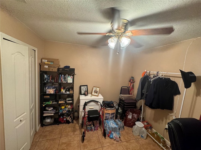 interior space with ceiling fan, light tile patterned floors, and a textured ceiling