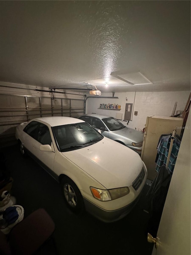 garage with a garage door opener and electric panel