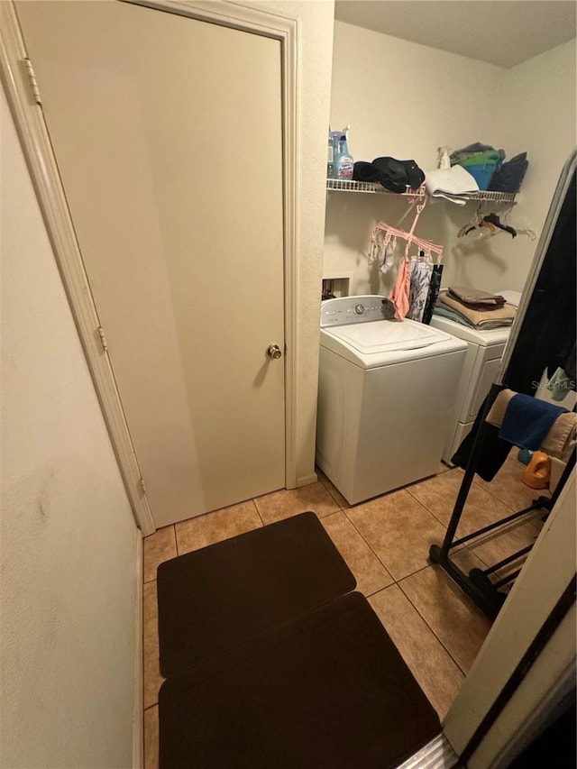 clothes washing area featuring light tile patterned floors and washing machine and dryer