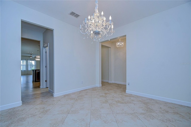 spare room with ceiling fan with notable chandelier