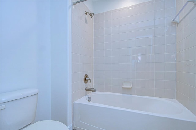 bathroom featuring tiled shower / bath combo and toilet