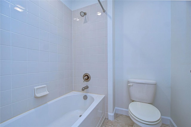 bathroom featuring tiled shower / bath combo, toilet, and tile patterned floors