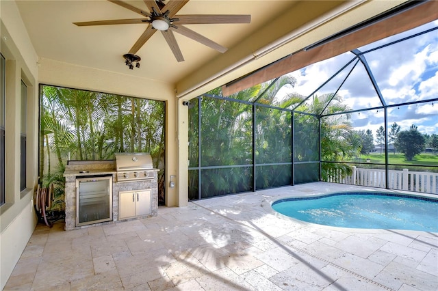 view of swimming pool with a patio, a lanai, an outdoor kitchen, grilling area, and ceiling fan