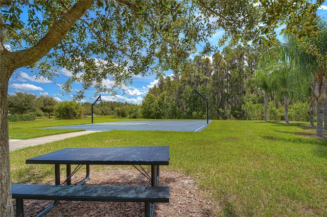 surrounding community featuring a lawn and basketball court