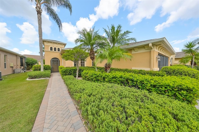 mediterranean / spanish home featuring a front yard and central AC