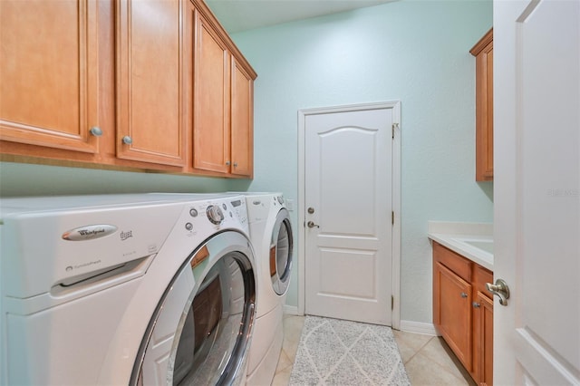 washroom featuring cabinets, washer and dryer, and light tile patterned flooring