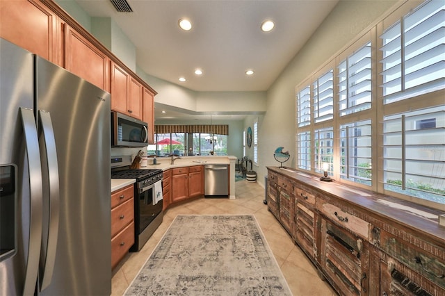 kitchen featuring light tile patterned floors, stainless steel appliances, and a healthy amount of sunlight