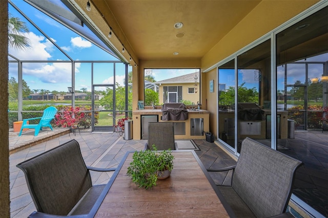 view of patio / terrace featuring a grill, a lanai, and sink