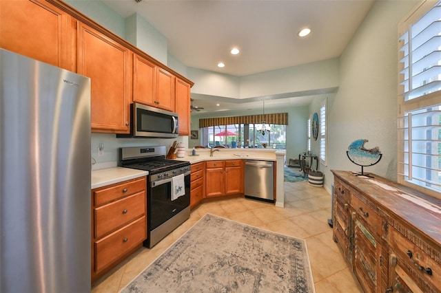 kitchen with pendant lighting, stainless steel appliances, and light tile patterned flooring