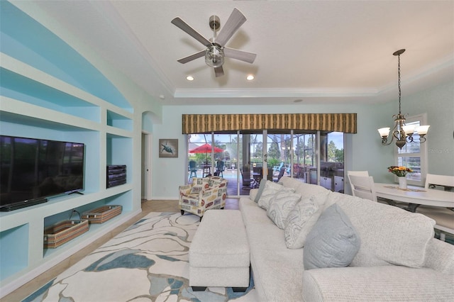 living room with built in shelves, light wood-type flooring, and ceiling fan with notable chandelier