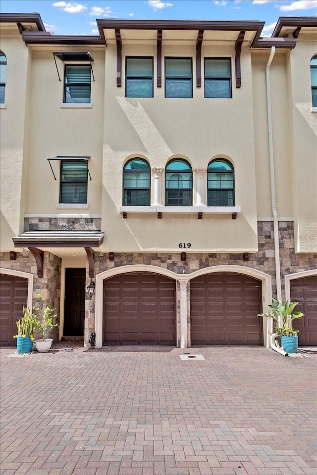619 Windward Cir S, Boynton Beach, FL 33435 - view of property with stone siding, stucco siding, an attached garage, and driveway